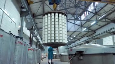 Tekstil fabrikasındaki kadın işçi iplik boyama makinesiyle çalışıyor. Tekstil Endüstrisi Makineleri, Boyama Makineleri Kimyasal Tankları ile boyama hikayelerinde modern teknoloji