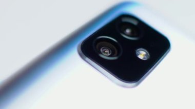 Akıllı telefondaki kamera birimine yakın çekim. Telefonun arkasında kamera flaşı ve mikrofon olan 2 lens.