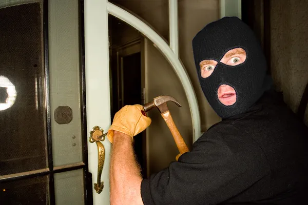 Um ladrão assaltando uma casa usando uma balaclava . — Fotografia de Stock