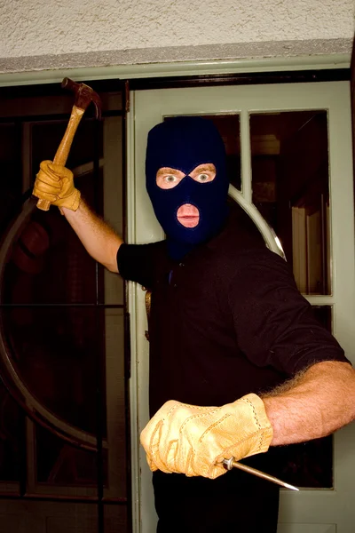 Um ladrão assaltando uma casa usando uma balaclava . — Fotografia de Stock