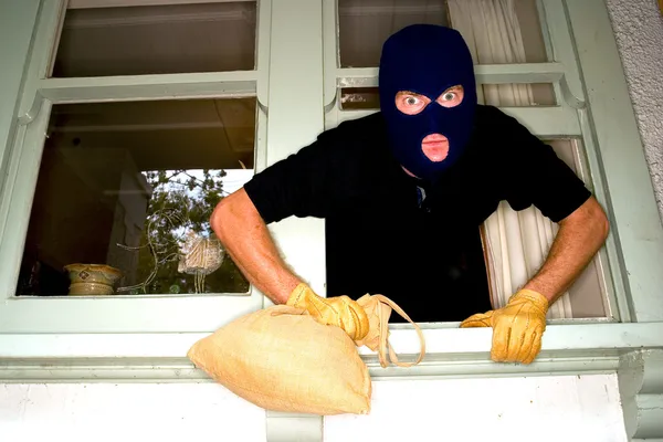 A burglar robbing a house wearing a balaclava. — Stock Photo, Image