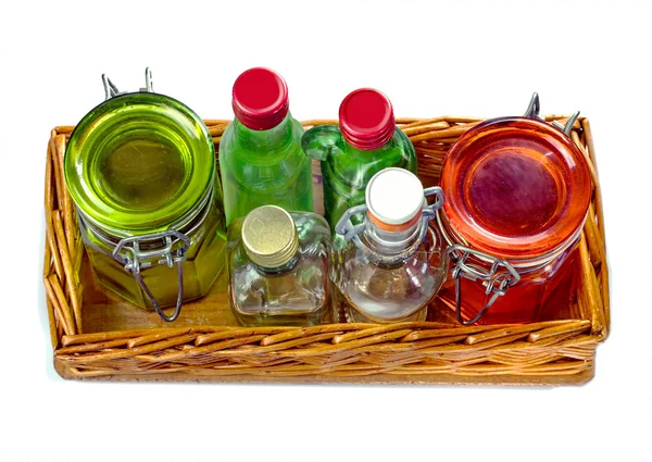 Salver de vime com frascos de vidro vazios e pequena garrafa de vidro — Fotografia de Stock