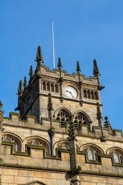 All Saints Kilisesi, Wigan Kilise 'si olarak da bilinir, arkasında mavi gökyüzü vardır. Aslen 13. yüzyılda inşa edilmiş ve 16. ve 17. yüzyıllara eklenen bu Anglikan kilisesi 2. derece olarak listelenmiştir. Wigan, Büyük Manchester, İngiltere.