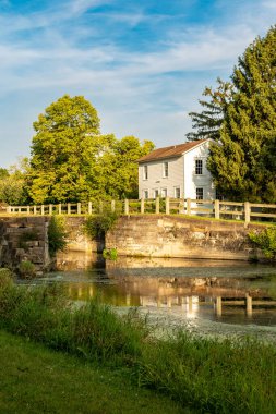 Gün batımı yaklaşırken tarihi Illinois ve Michigan Kanalı boyunca Locktenders evleri ve kanalları kilitleniyor. Aux Sable, Illinois, ABD.