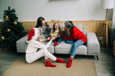 Noel 'i kutlayan çocukla aynı cinsiyetten aile. Bayan aile Noel 'i birlikte kutlar. Orta halli insanlar.