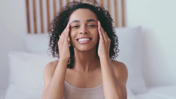Szépség reggeli rutin koncepció. Fiatal afrikai nő arcmasszázzsal. Arcödéma enyhítésére egy éjszaka után. Bőrápolás. — Stock videók