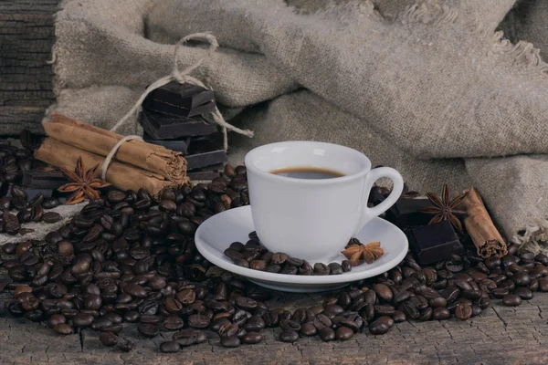 Taza de café con granos de café, chocolate y especias — Foto de Stock