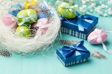 renkli yumurta yuvada ve mavi kutu içinde sunar