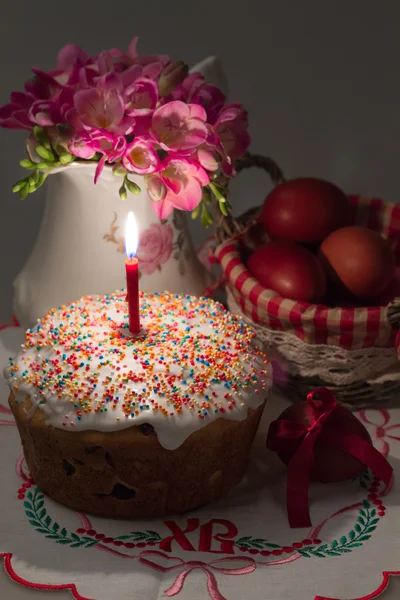 Pastel de Pascua con una vela encendida, flores y huevos pintados —  Fotos de Stock