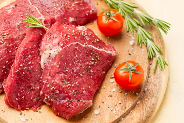 Rebanadas de carne en sal y pimienta, romero y tomates —  Fotos de Stock