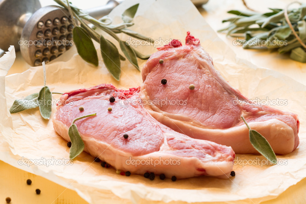 Raw pork with pepper and clary in a paper (horizontal shot)