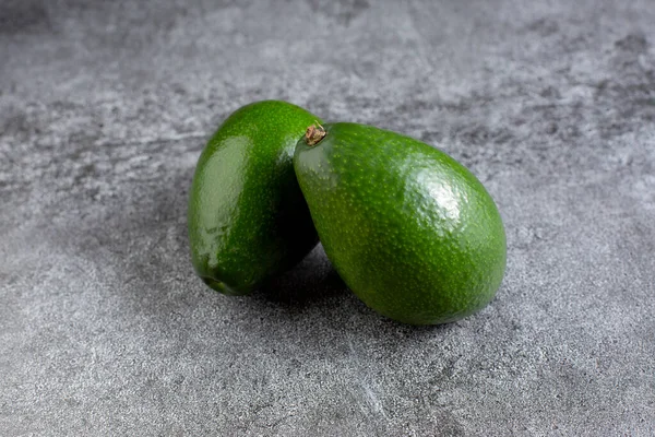 Два Зелених Авокадо Лежать Штучній Кам Яній Дошці Дієтична Їжа Ліцензійні Стокові Фото