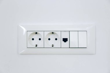 Elektrik düğmesi ve beyaz duvardaki soket