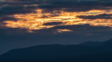 Gün batımında turuncu renklerle hareket eden bulutlar