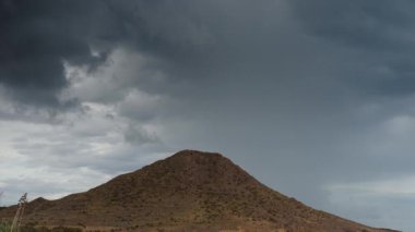 Hızla hareket eden bulutları olan bir sahilde büyük bir fırtına.