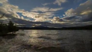 Gölün üzerinde bir gün batımında fırtına bulutları