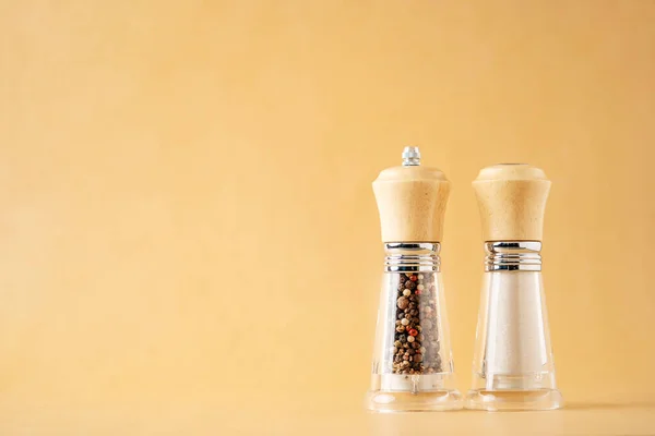 Glass salt and pepper shakers on white beige background