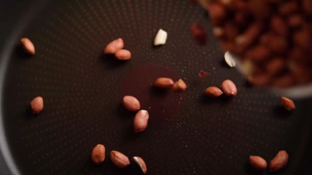 Dejte do kůže arašídy v pánvi na pečení. — Stock video
