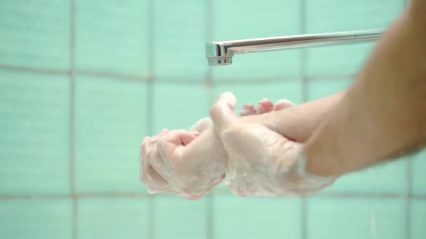 Mains homme se laver les mains dans l'évier avec de la mousse pour laver la peau par les mains. — Video