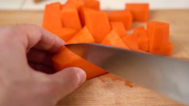 男性の手は調理のための生のカボチャをみじん切り,ナイフでキューブの作品にカット. — ストック動画