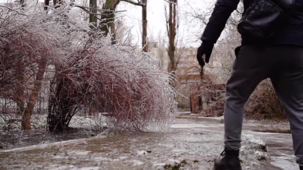 Mężczyzna w zimowej sukience poślizgu na chodniku z lodem zbliżenie — Wideo stockowe