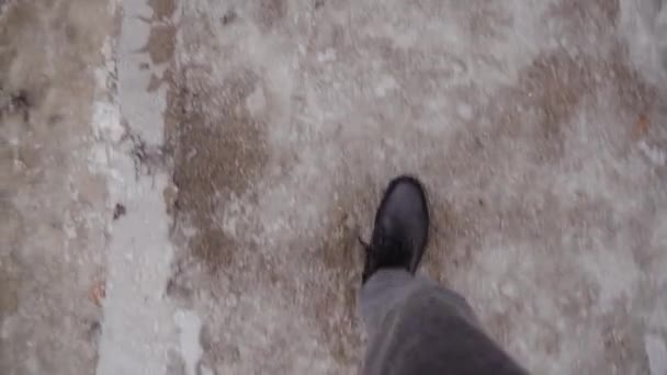 Legs man in black boots walking on slippery ice on streets in winter. Pov video — Wideo stockowe