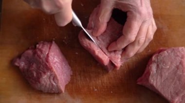 Taze domuz eti kesme tahtasındaki bir bıçakla dilimlenir. Üst görünüm