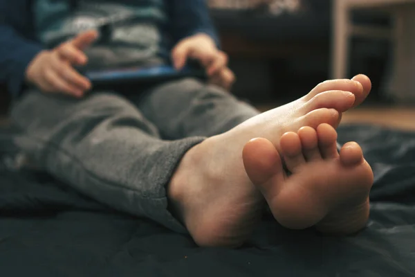 Çocuk evde akıllı telefondan video oyunu oynuyor.