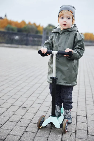 Boy ride a scooter along the embankment — Stock Photo, Image