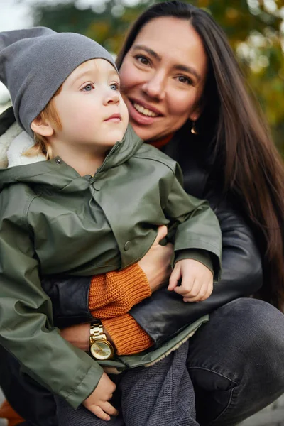 美しい女性が公園で息子を抱きしめる — ストック写真