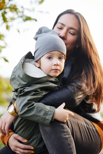 Όμορφη γυναίκα με ένα μωρό στην αγκαλιά της. στο πάρκο — Φωτογραφία Αρχείου