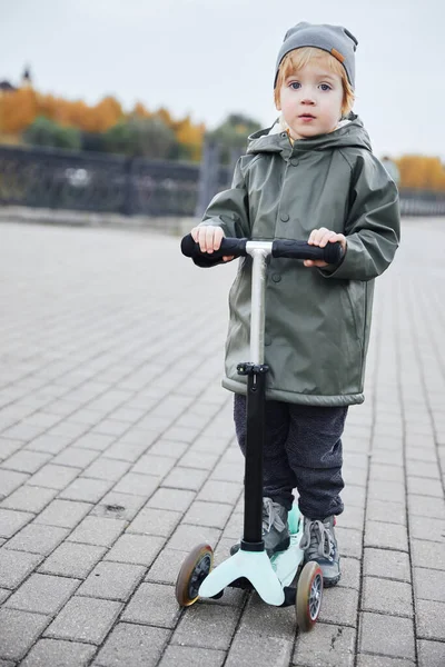 Мальчик катался на скутере по набережной Лицензионные Стоковые Изображения