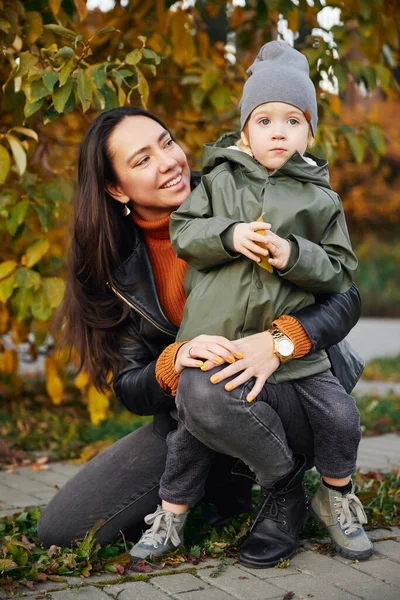 Bella donna abbraccia suo figlio nel parco Fotografia Stock