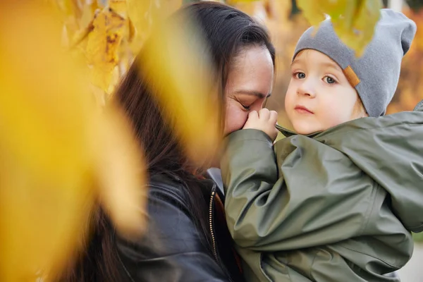 Bellissima donna con un bambino tra le braccia. nel parco Foto Stock