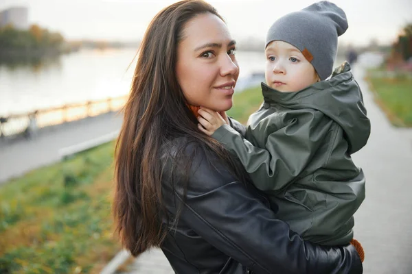 Bellissima donna con un bambino tra le braccia. nel parco Foto Stock Royalty Free