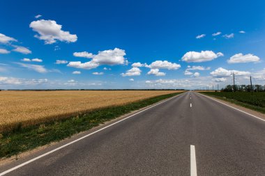 Mavi Gökyüzü bulutlu asfalt yol üzerinde