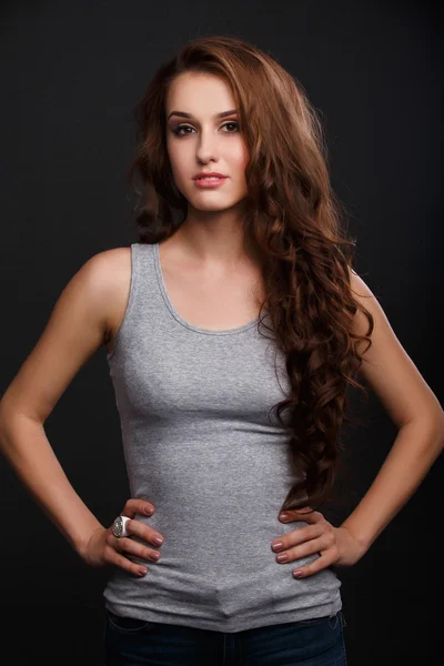 Chica en camiseta gris sobre un fondo oscuro Fotos de stock libres de derechos
