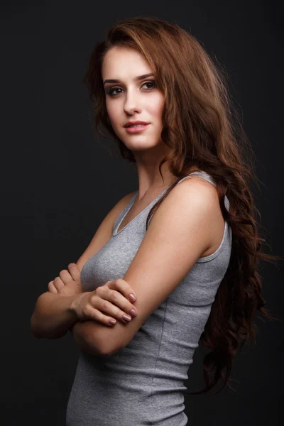 Girl in grey shirt on a dark background — Stock Photo, Image