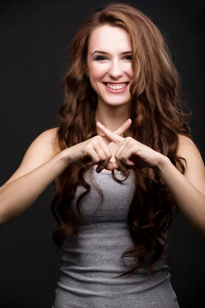 Beautiful smiling girl the cross fingers — Stock Photo, Image