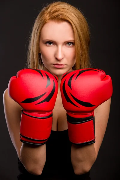 güzel bir kadın kırmızı boks eldivenli koyu arka plan