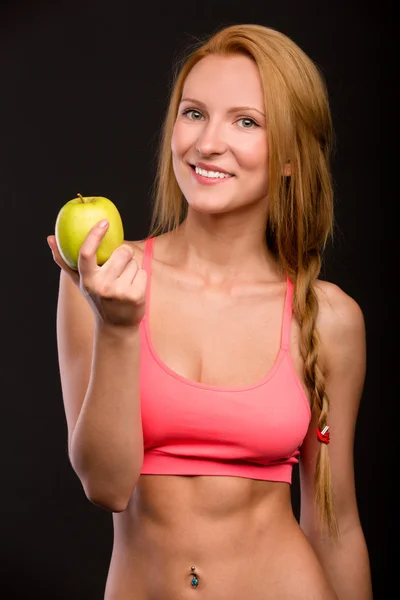 Schönes lächelndes Mädchen mit Apfel in der Hand lizenzfreie Stockbilder