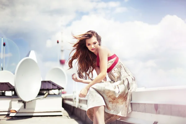 Beautiful woman in elegant dress on the top of modern building — Stock Photo, Image