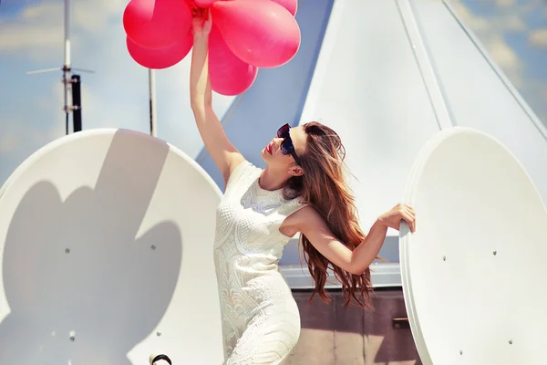 balonları modern binanın tepesinde şık elbiseli güzel kadın