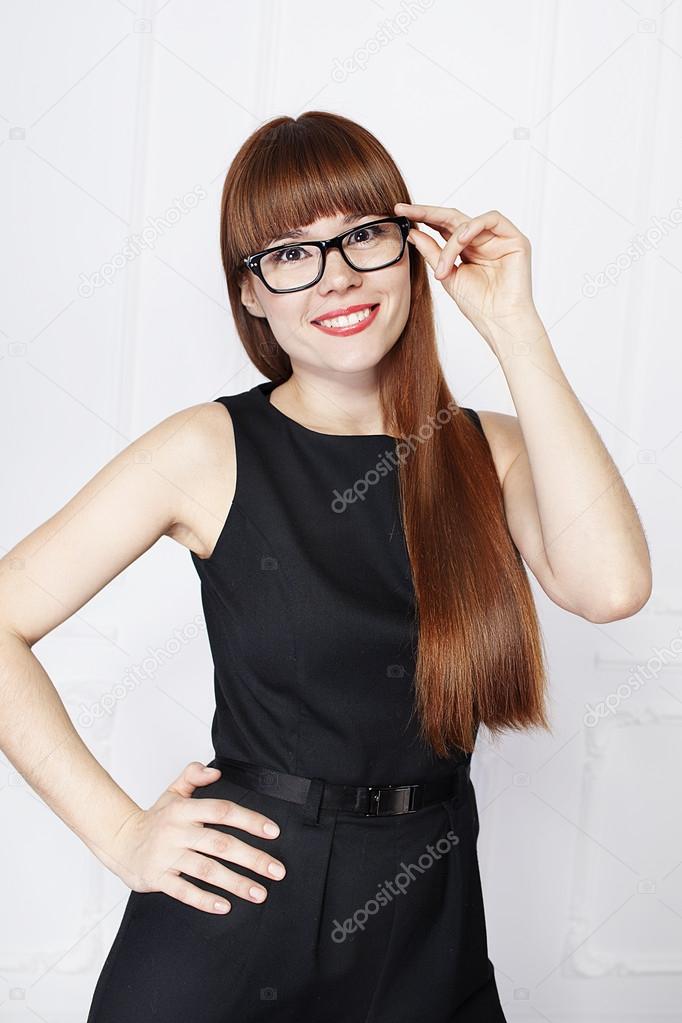 Beautiful woman with red hair in black glasses and black jumpsuit