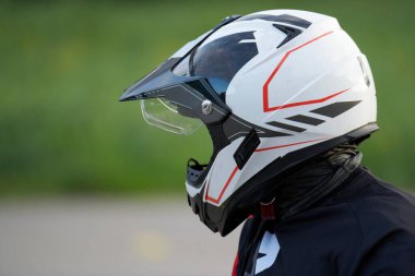 Beyaz kasklı kadın motosikletçiye yakından bakın..