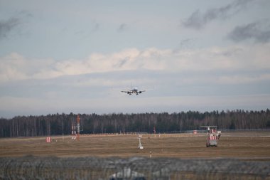 Mavi bulutlu gökyüzü karşı havaalanında uçak iniyor