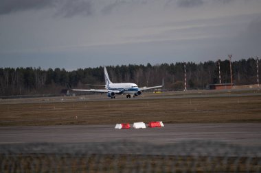 Mavi bulutlu gökyüzü karşı havaalanında uçak iniyor