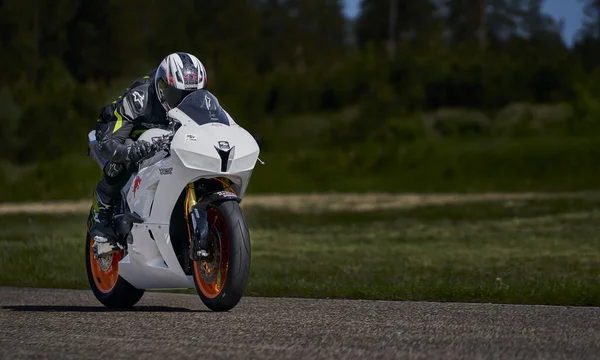 2021年5月11日 拉托维亚摩托车手里加 Riga 在空旷的沥青路面上骑摩托车 跑车大奖赛 超级自行车 摩托车比赛 白色运动摩托车黑衣男士 — 图库照片