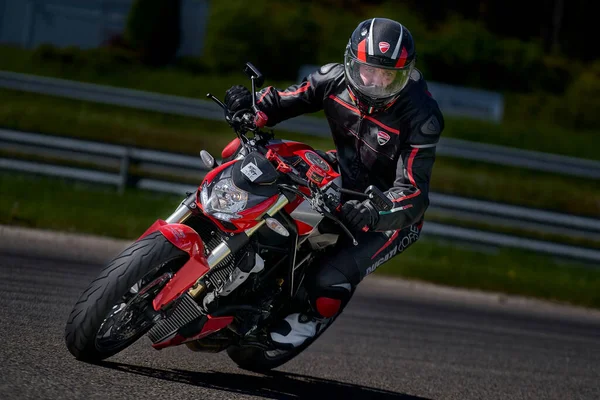 2021ラトビアのリガ空のアスファルトの道路によるスポーツバイクの乗り物でオートバイ 黒い赤い通りのバイク Motogpレース スーパーバイク オートバイレース 黒のスーツと黒のヘルメットのオートバイ — ストック写真