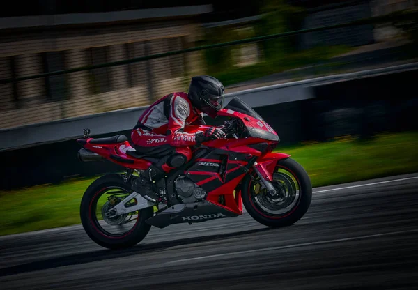 2021年5月11日 拉托维亚摩托车手里加 Riga 在空旷的沥青路面上骑摩托车 跑车大奖赛 超级自行车 摩托车比赛 身穿红白相间西服的男子骑红色摩托车 — 图库照片